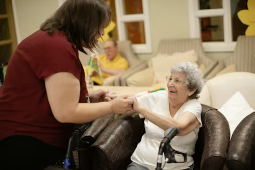 smiling woman with caretaker helping her
